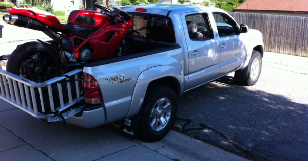 Load a motorcycle in the back of a truck