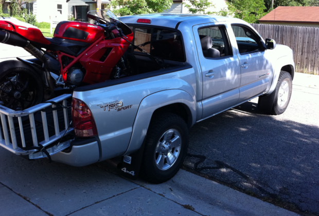 Load a motorcycle in the back of a truck