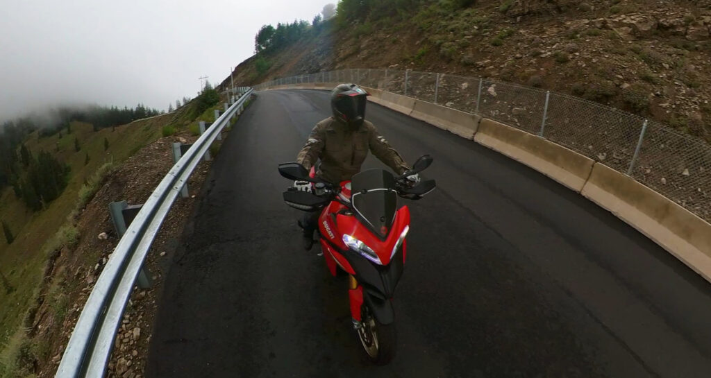 Ducati Multistrada Motorcycle riding a steep downhill corner in the rain