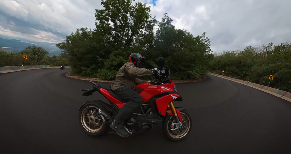 Ducati multistrada motorcycle trail braking through a corner in the rain