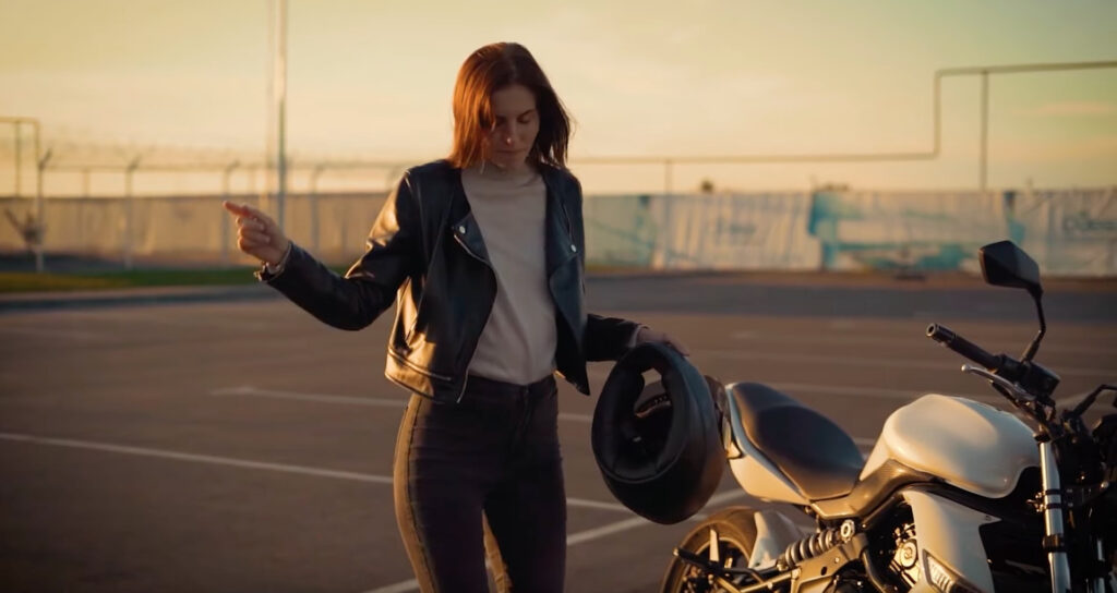 Woman dancing next to her motorcycle