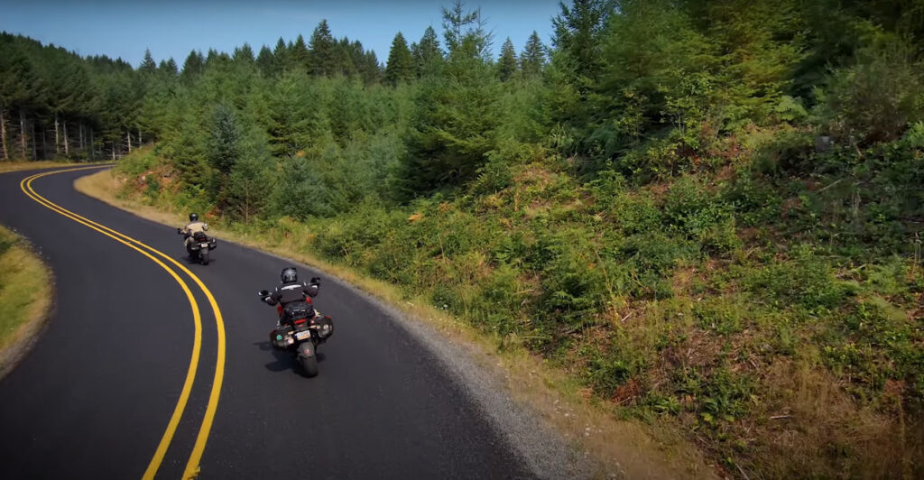Two motorcycles riding a canyon road