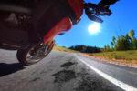 Motorcycle Leaning in a corner on a road in bad condition