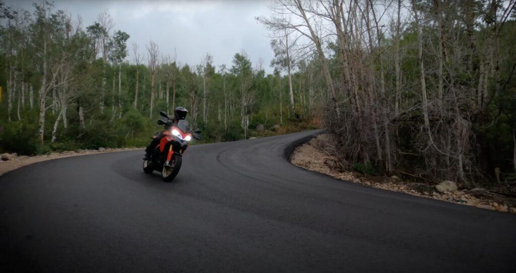 Motorcycle riding through a downhill, wet corner