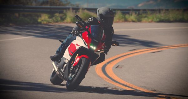 A rider leaning a sportbike through a mountain corner