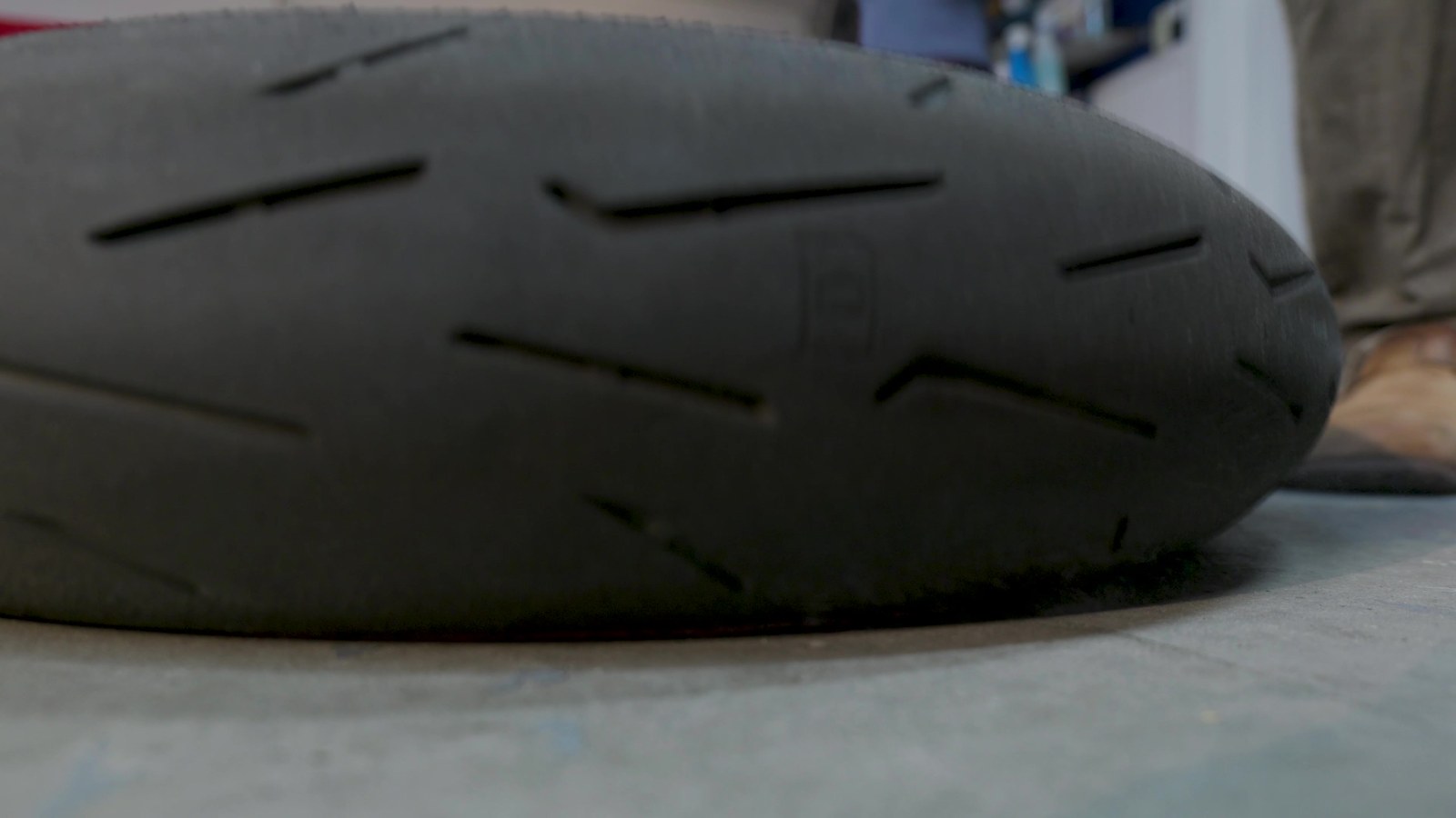 Close-up of a motorcycle tire pressed against the ground, showing the contact patch