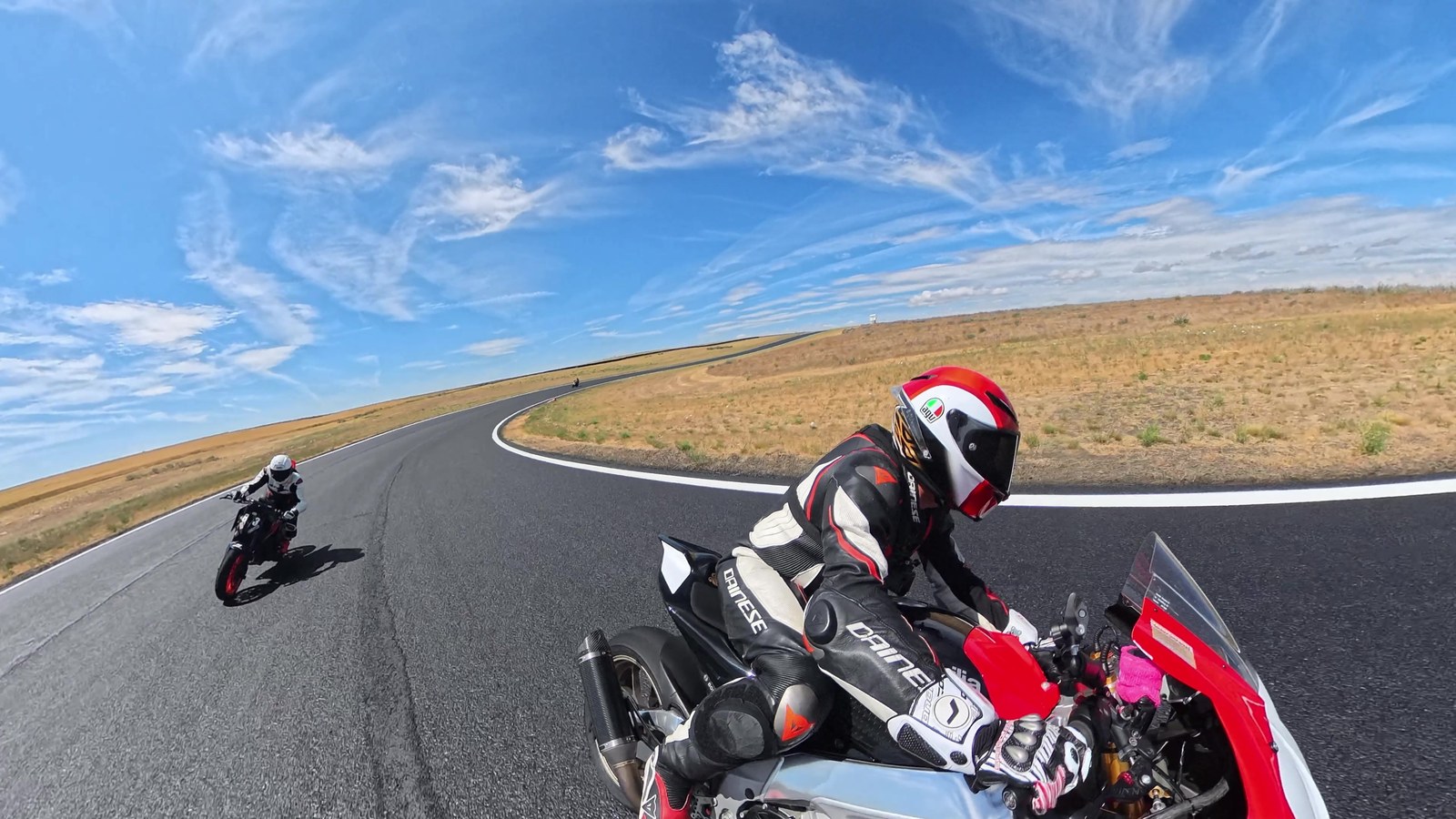 A rider leaning a sportbike through a fast sweeping corner