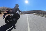 A motorcycle leaning into a sunlit canyon corner