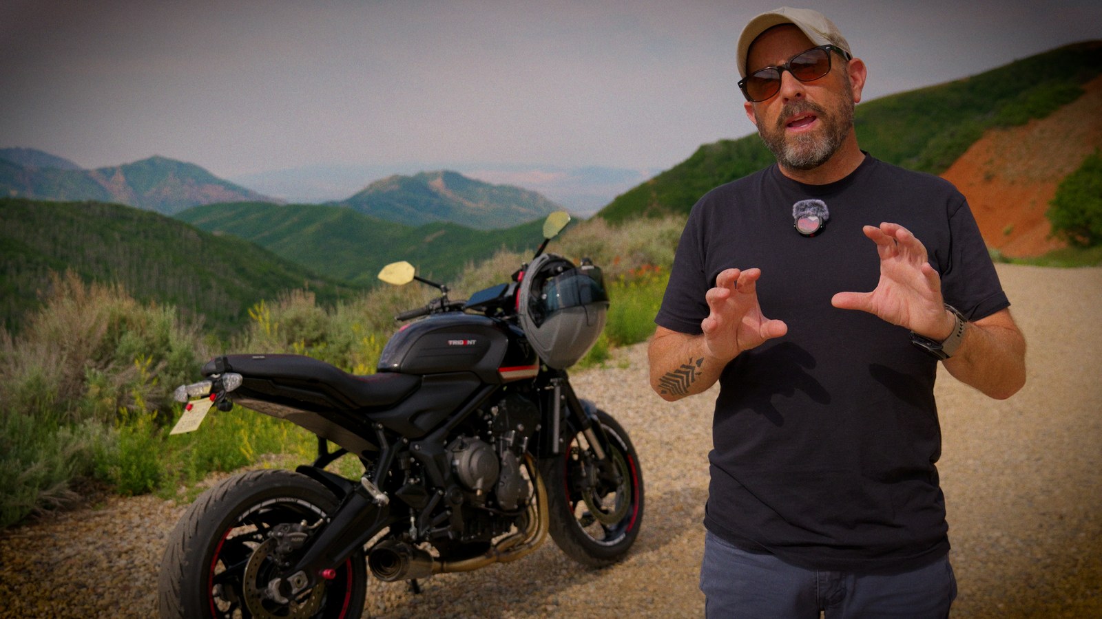 Insta360 Mic Pro clipped to a rider's chest with a Triumph Trident parked on a mountain road