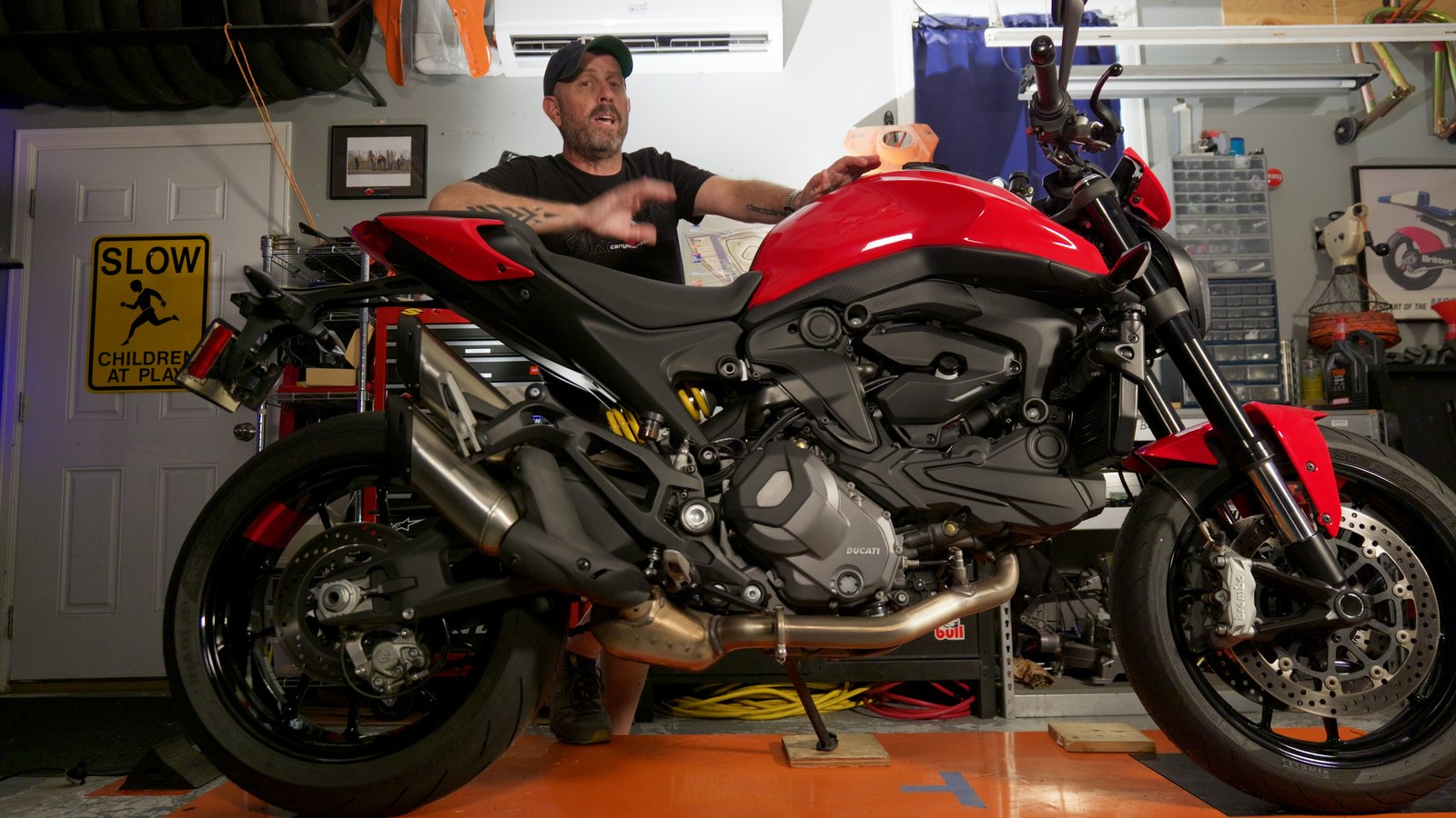 Dave standing behind the red 2024 Ducati Monster Plus in his garage