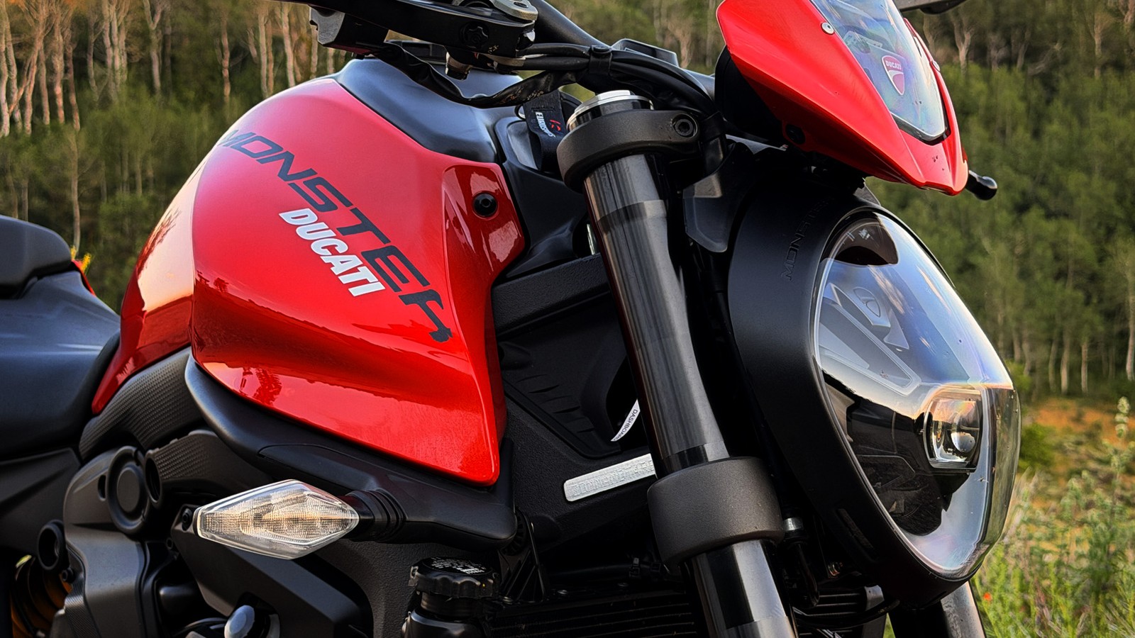 2024 Ducati Monster Plus in red parked at a mountain overlook, tank and front end in focus
