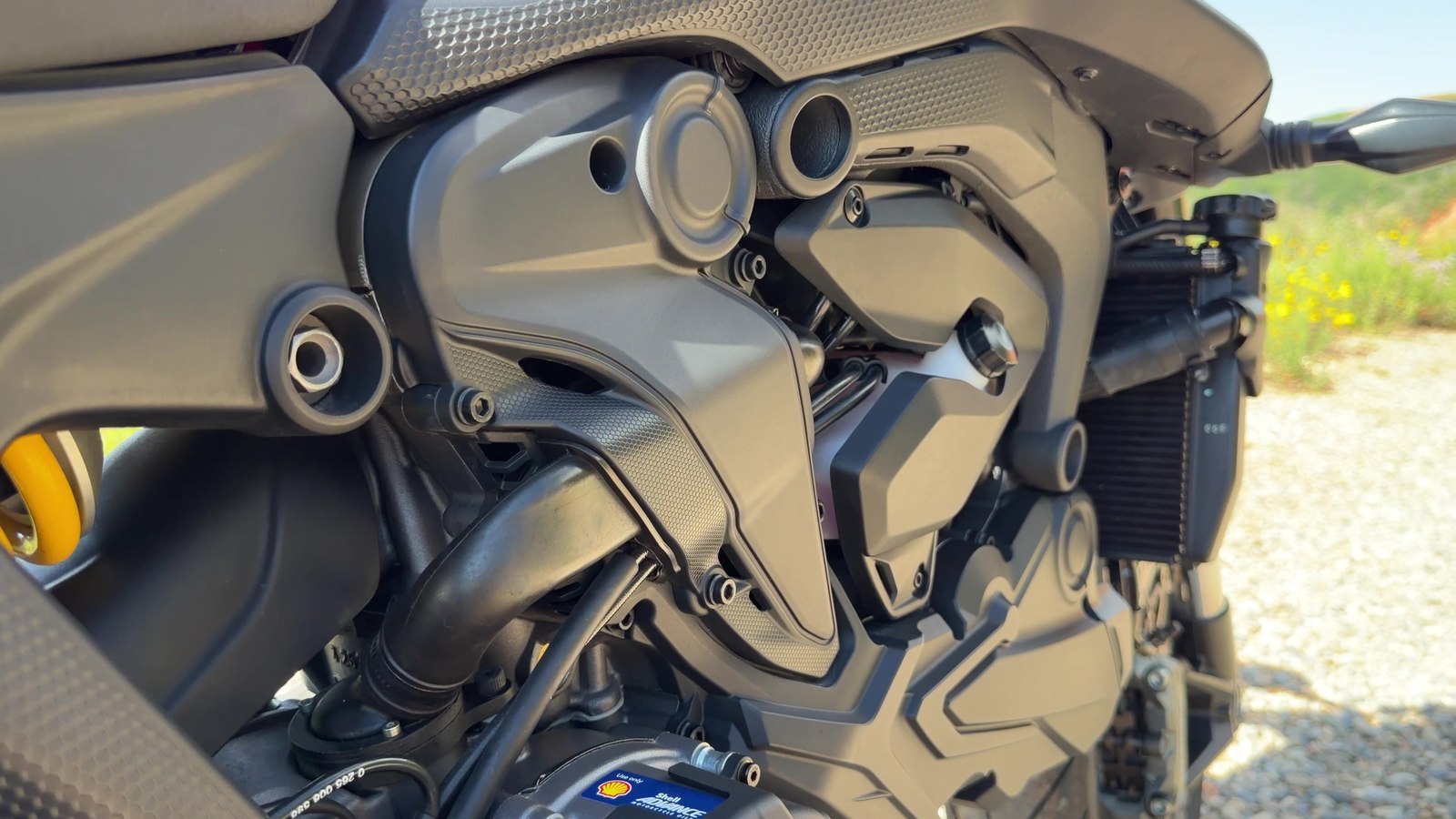 Close-up of the Ducati Monster exhaust headers and undertail area where the rear brake line runs