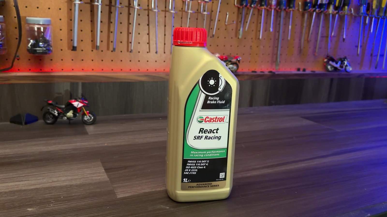 A bottle of Castrol React SRF Racing brake fluid on a workbench