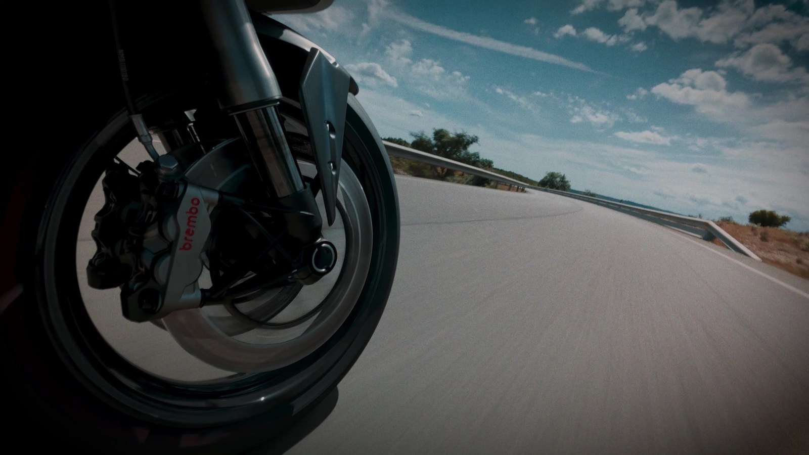 Close-up of the front wheel, brakes, and fork of the Norton Manx R while riding