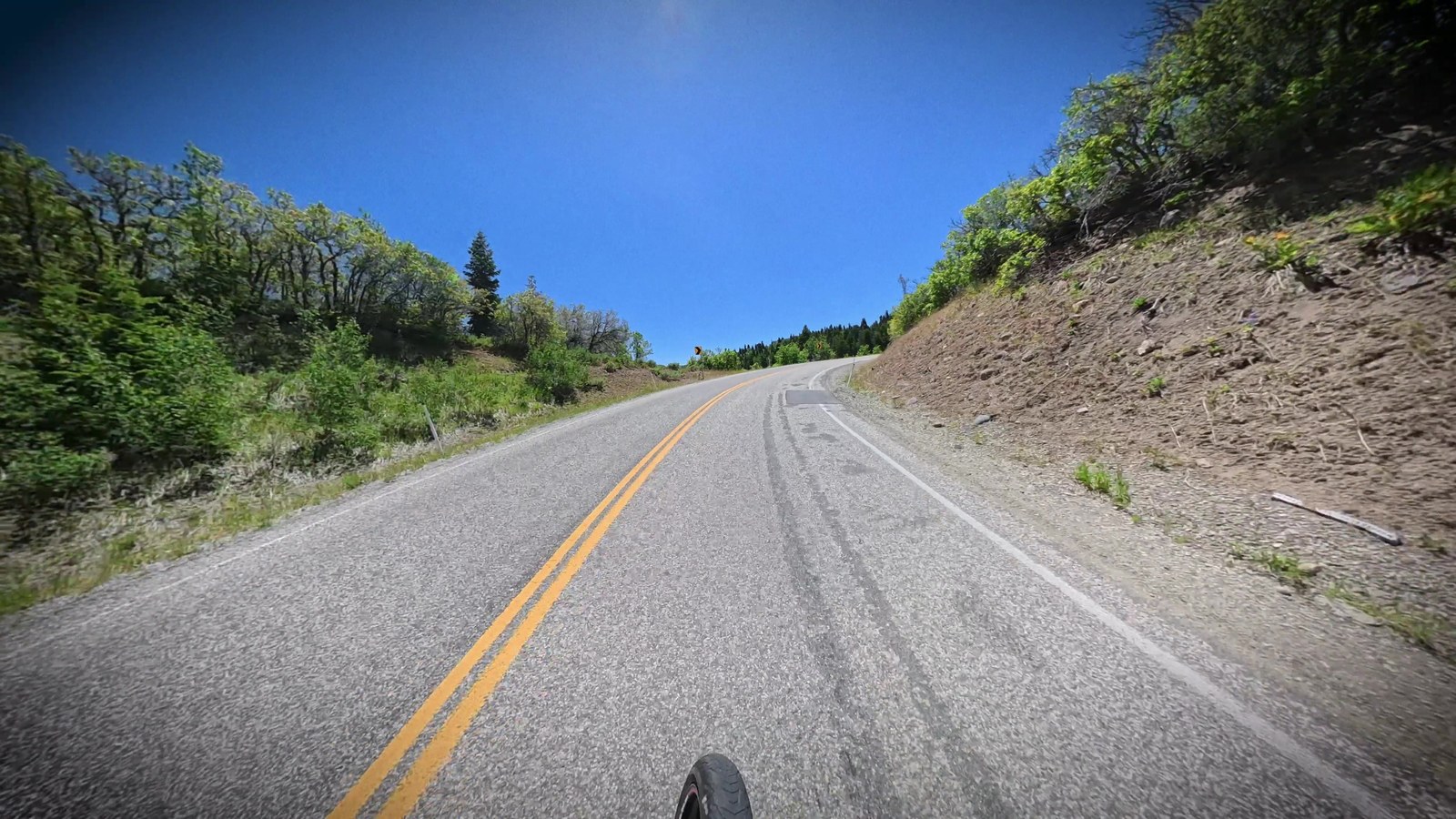 Point-of-view shot riding down an open canyon road on a clear day