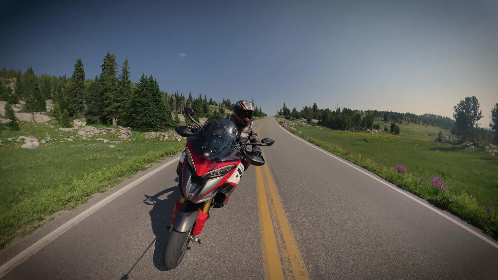 A red Ducati Multistrada passing the camera set at the roadside on an alpine road
