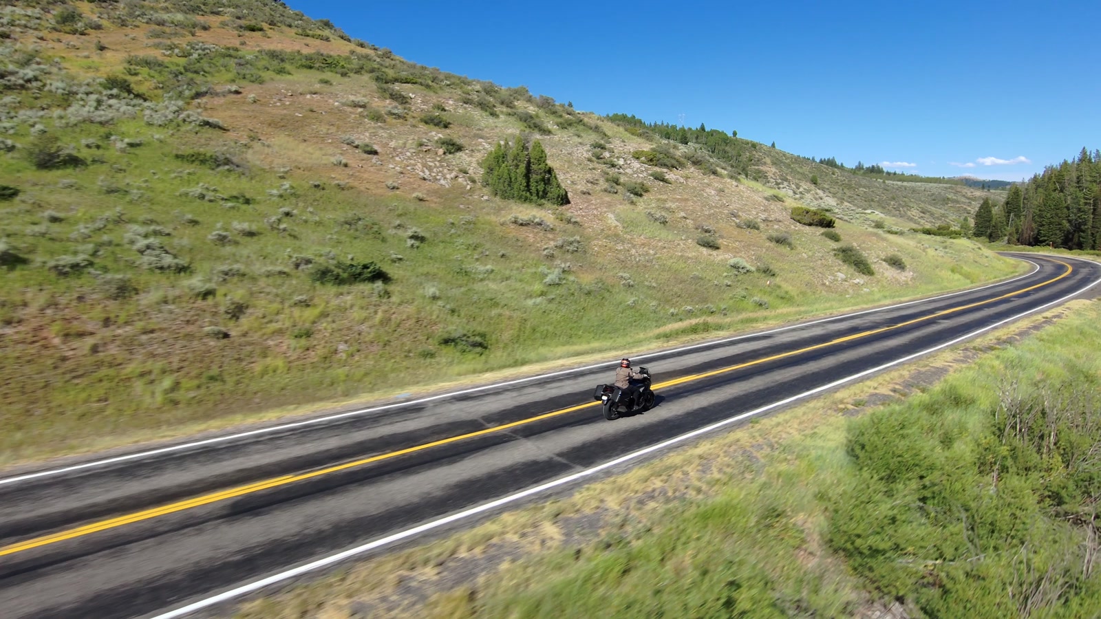 A high, side-on follow across open country with nothing overhead.