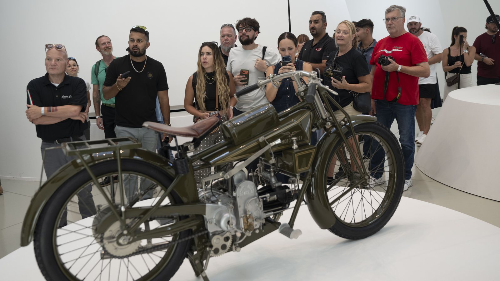 Visitors gathered around one of the earliest Moto Guzzi motorcycles in the museum