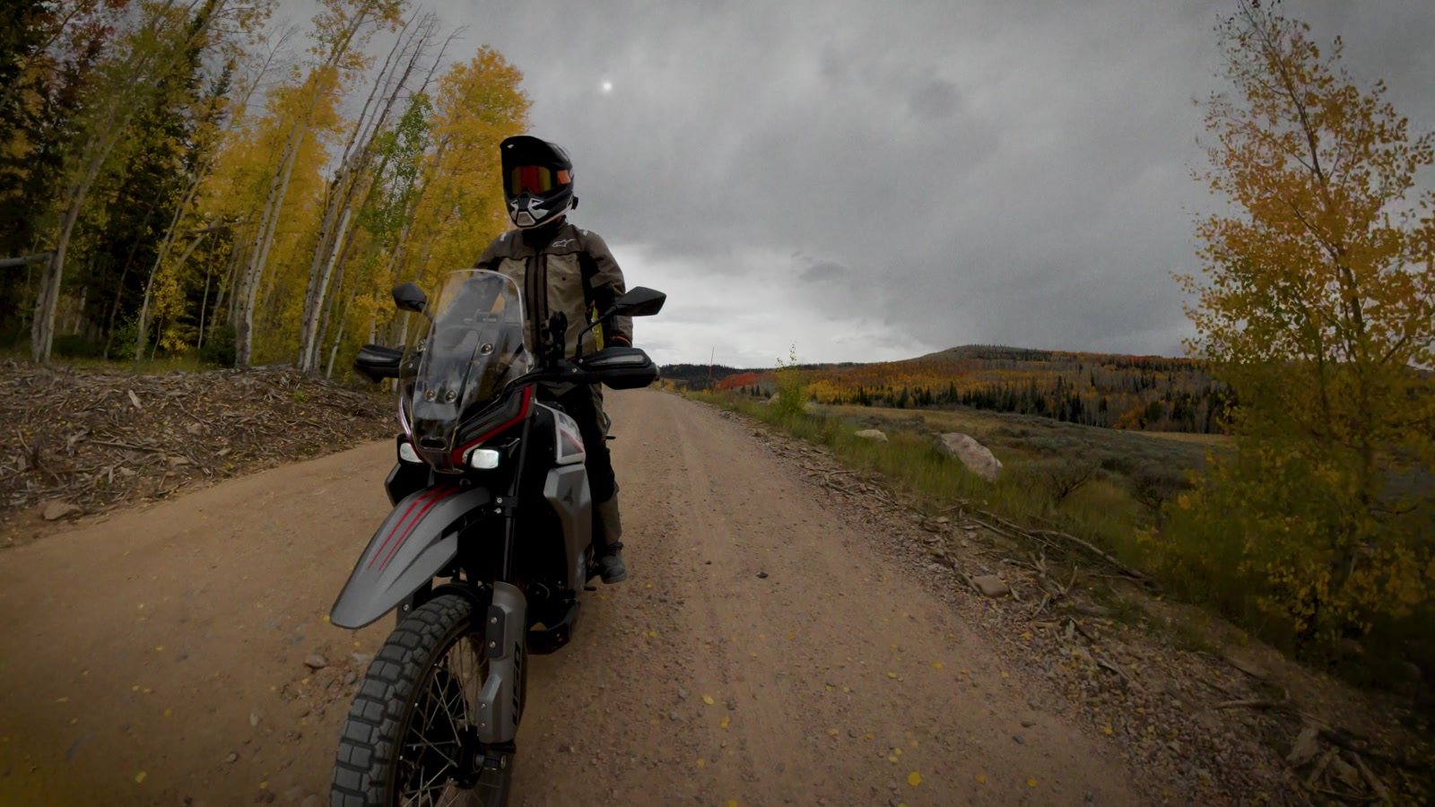 Moto Morini Vettore 450 approaching on a gravel road with storm clouds overhead